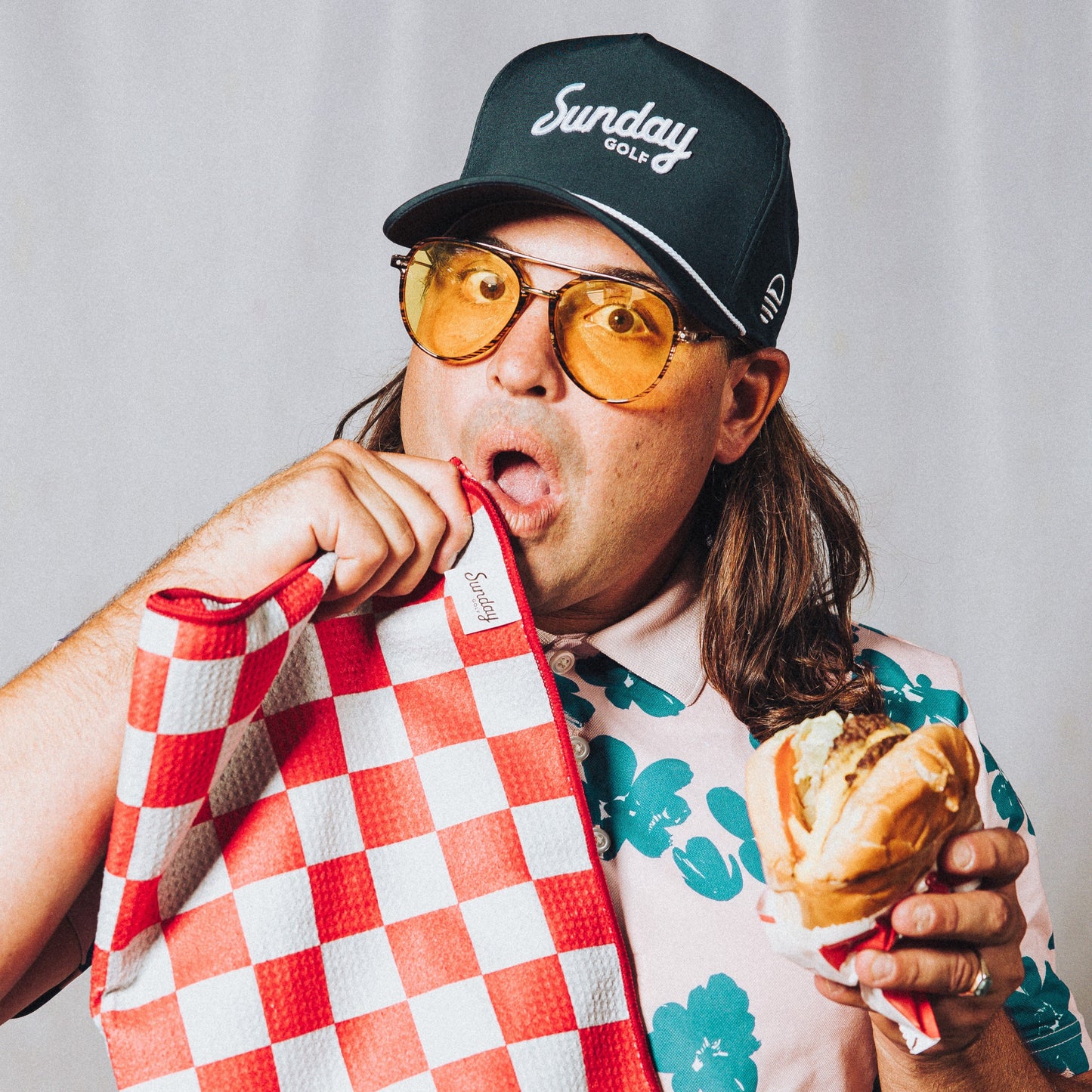 man eating in n out wearing navy rope hat