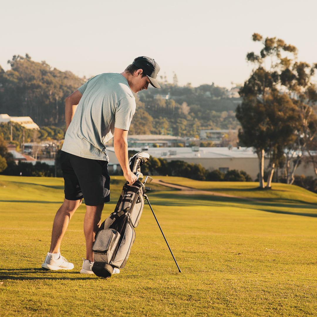 man carrying Loma XL Gray Sunday Golf Bag on the course