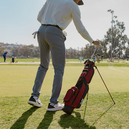 man on golf course with deep red burgundy Loma Bag by Sunday Golf