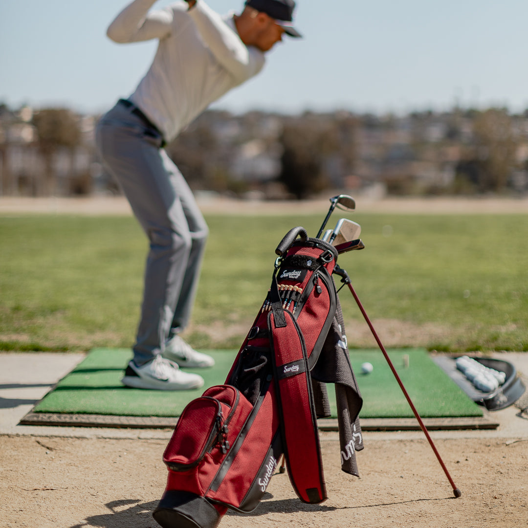 deep red burgundy golf bag at driving range 