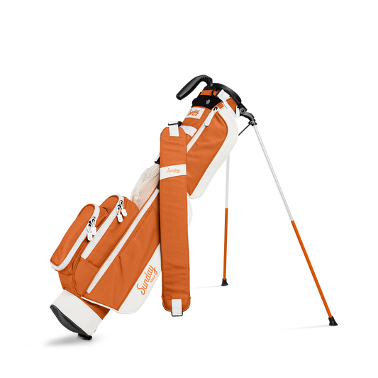 A full front shot of standing Loma golf bag in burnt orange with single strap